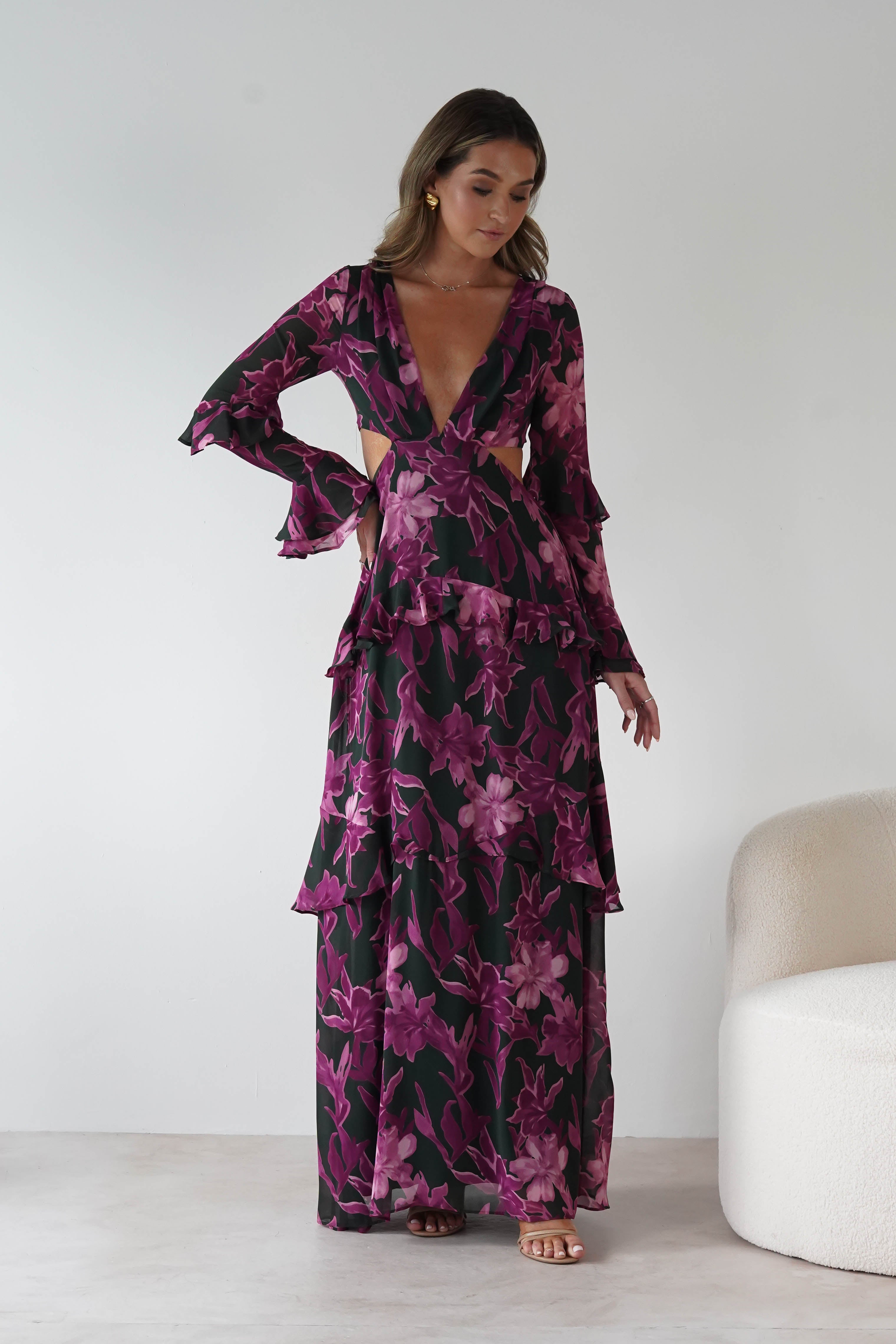 Woman wearing a floral dress with cut-out design in a minimalistic setting