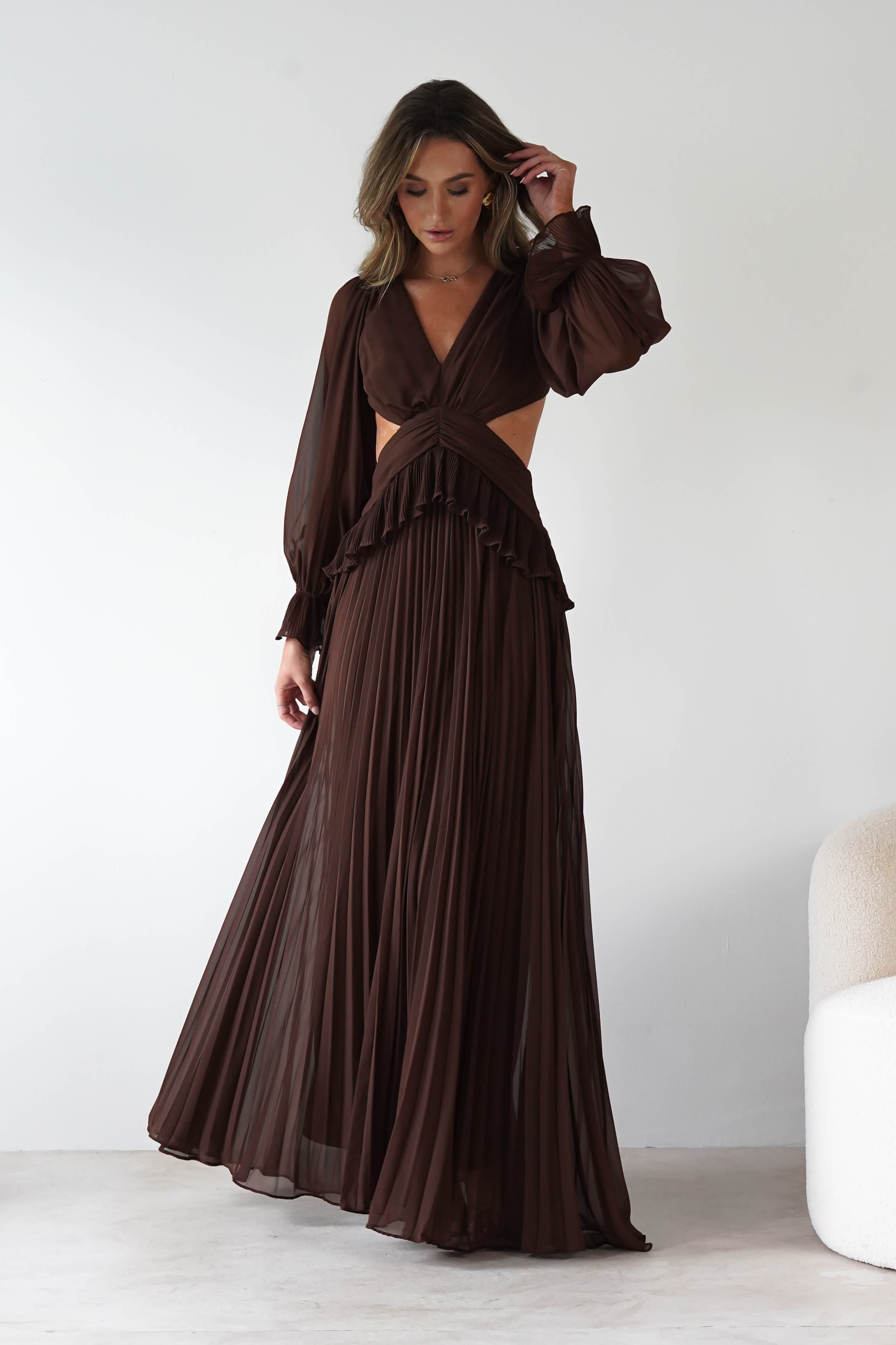 Woman wearing a brown dress with cut-out design against a white background