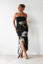 Woman wearing a strapless dress with floral design against a white background