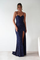 Woman wearing Nalita Bodycon Sequin Gown in navy with sweetheart neckline, sparkling sequin finish, bodycon fit, and thigh-high leg slit.