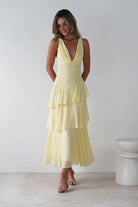Model wearing a pastel yellow V-neck ruffle tiered maxi dress with a fitted bodice and flowy chiffon layers—ideal for weddings, summer events, or garden parties.