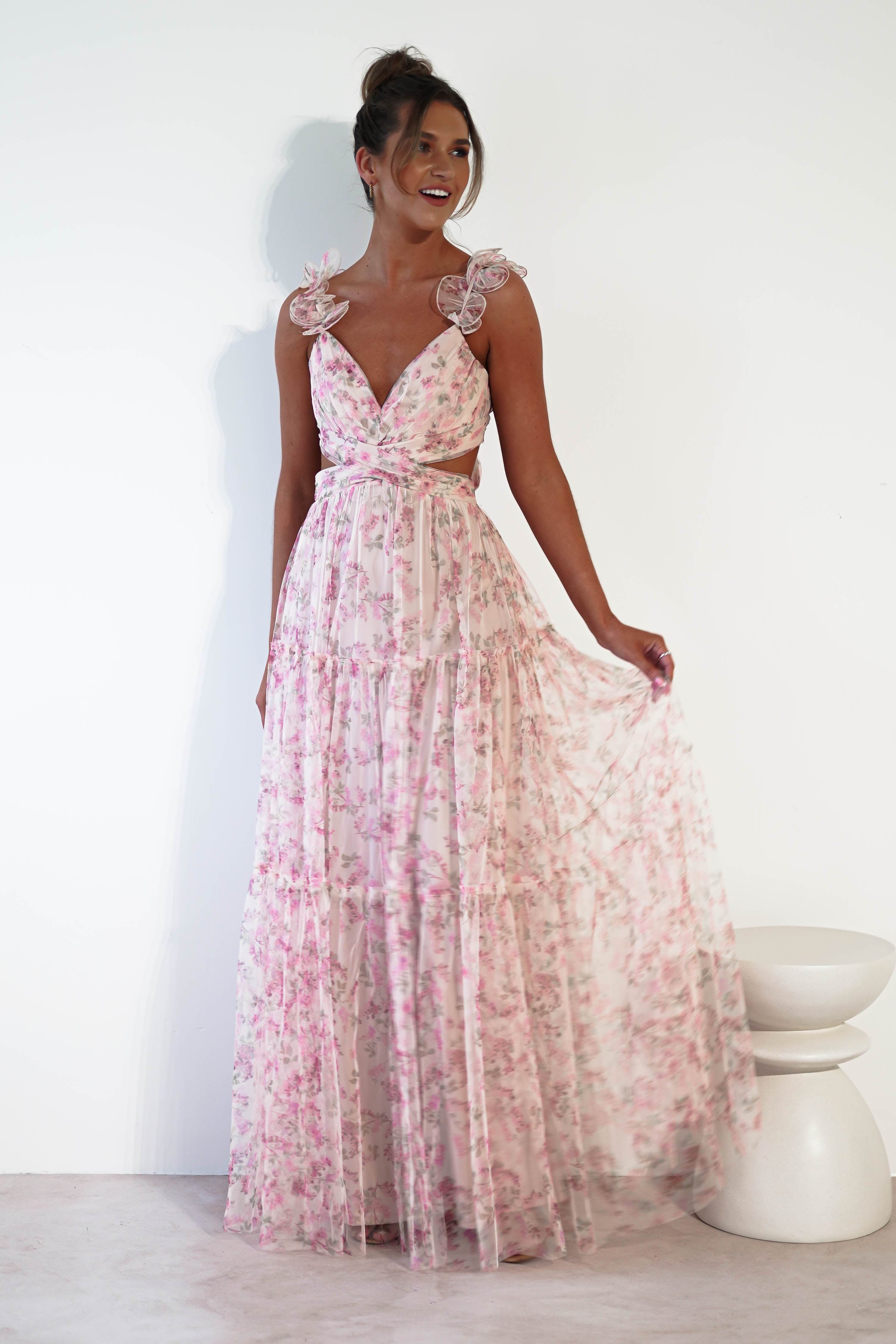 A woman in a floor-length, sleeveless pink floral tulle maxi for our womens dress sale collection